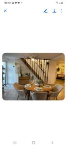 a dining room with tables and chairs and a staircase at Le gîte des Romains in Anor