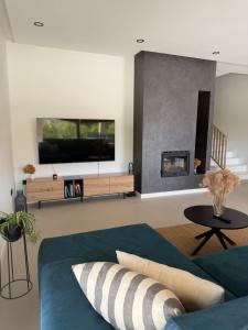 a living room with a blue couch and a fireplace at Villa Karpa in Pridraga