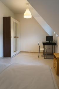 a bedroom with a bed and a desk with a computer at Lakeview Apartment in Ostriach