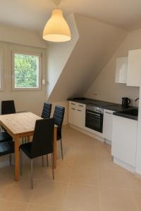 a kitchen with a wooden table and black chairs at Lakeview Apartment in Ostriach