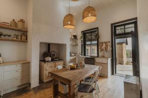 a kitchen with a wooden table and some lights at Waterval Guest Farm in Bloemfontein
