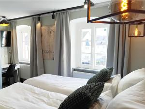 a bedroom with two beds and two windows at NOX HOTEL - Digital-Check-In - No Reception - nahe Bretten & Karlsruhe - 4 Essence in Wössingen