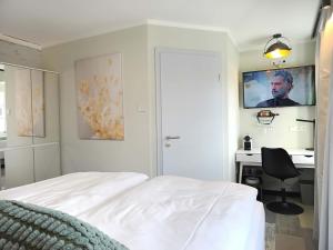 a bedroom with a bed and a desk with a tv on the wall at NOX HOTEL - Digital-Check-In - No Reception - nahe Bretten & Karlsruhe - 4 Essence in Wössingen
