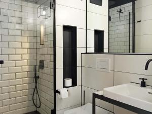 a white bathroom with a sink and a mirror at NOX HOTEL - Digital-Check-In - No Reception - nahe Bretten & Karlsruhe - 4 Essence in Wössingen
