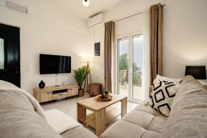 a living room with a couch and a tv at Villa Margarita in Nótos