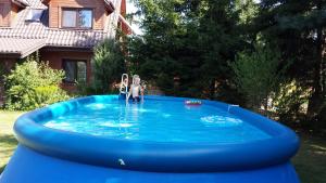 a couple of people in a blue inflatable pool at Kwiatowa Zagroda in Białowieża
