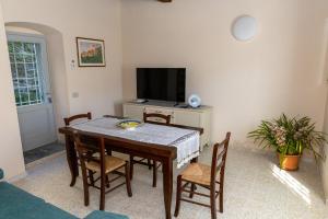 a dining room with a table and chairs and a television at Arco delle Apuane by Migliorini in Stazzema