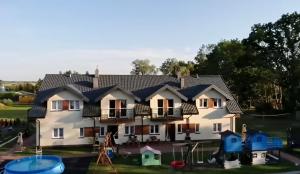 a house with a playground in front of it at Apartamenty Koło Brzegu in Gąski