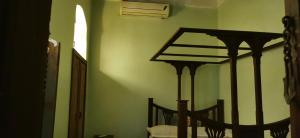 a bedroom with a bed in a room with green walls at Arizona apartment in Zanzibar City