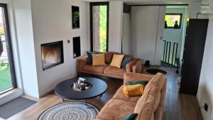 a living room with two couches and a table at Apartment in Vichte 1 Bedroom in Anzegem