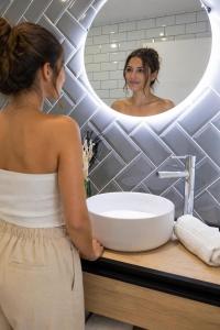 a woman standing in front of a sink in a bathroom at CASA FLORIT - The Maritim Serreria Suites in Valencia
