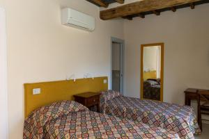 a hotel room with two beds and a mirror at Arco delle Apuane by Migliorini in Stazzema
