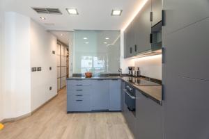 a large kitchen with white cabinets and blue counters at Club Atlantis 159 in Adeje