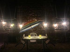 a table with an umbrella and chairs at night at Treignac Tourelles in Treignac +13 photos