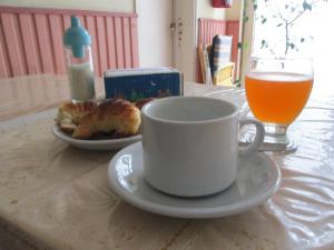 una taza de café y un plato de comida y un vaso de zumo de naranja en Hotel Perla Central en Mar del Plata