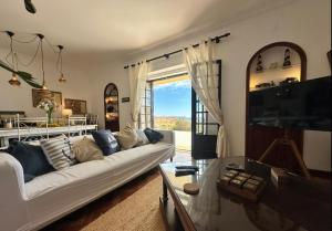 a living room with a white couch and a table at Casa dos Rebolinhos in Sagres