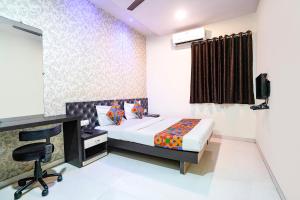 a bedroom with a bed and a desk and a computer at FabHotel Marvey Residency in Mumbai
