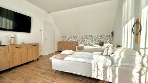 a bedroom with two beds and a tv on the wall at TJ Nyaraló in Markaz