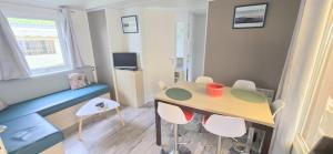 a small living room with a table and chairs at Bungalow-Mobilhome - Petit prix- Océan -Forêt -Camping 3 étoiles in Bias