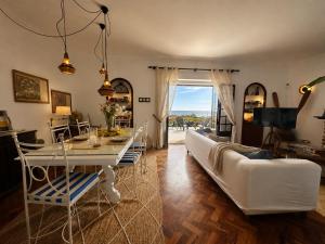 a living room with a white couch and a table at Casa dos Rebolinhos in Sagres