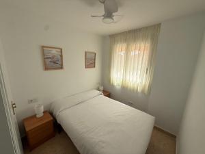 a bedroom with a white bed and a window at Respiro di Levante in Oropesa del Mar