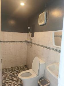 a bathroom with a toilet and a sink and a fan at ดอกฟ้า ม่อนแจ่ม in Mon Jam