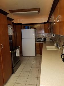 a kitchen with a white refrigerator and a sink at Charming 3-Bedroom House Steps from Luquillo Beach in Luquillo