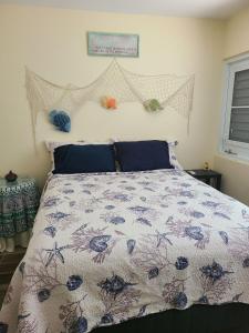 a bedroom with a bed with a floral bedspread at Charming 3-Bedroom House Steps from Luquillo Beach in Luquillo +4 photos