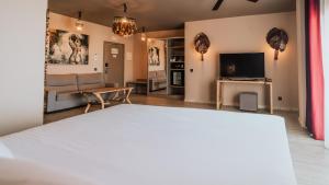 a bedroom with a bed and a living room at Hotel Tarifa Lances, a member of Radisson Individuals in Tarifa