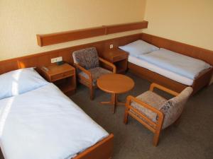 a room with two beds and a table and chairs at Gasthof zum Galik in Großkrut