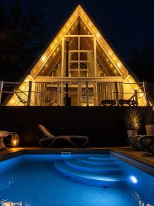 a house with a swimming pool at night with lights at Fazenda Wood in Mlynki