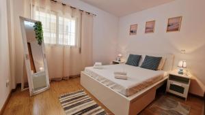 a bedroom with a large white bed and a mirror at Island Dream Apartment in Olhão +36 photos