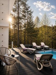 a deck with lounge chairs and a swimming pool at Fazenda Wood in Mlynki