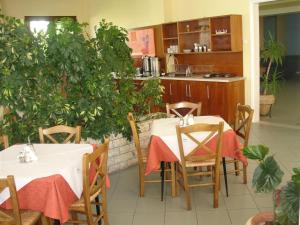 jadalnia z dwoma stołami i kuchnią w obiekcie Hotel Kronio w mieście Olimpia