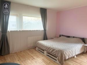 a bedroom with a bed and a large window at Lilac room in Ozolnieki