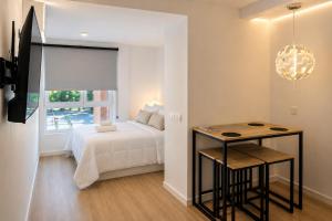 a bedroom with a bed and a table and a window at Nova MSuites Valencia in Valencia +6 photos
