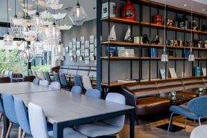 a dining room with tables and chairs and chandeliers at Motel One Hamburg-Alster in Hamburg