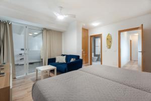 a hotel room with a bed and a blue chair at Casa Vistahermosa in Chayofa
