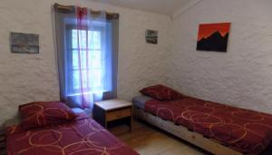 a bedroom with two beds and a window at Habitation Occitania in Durban-Corbières