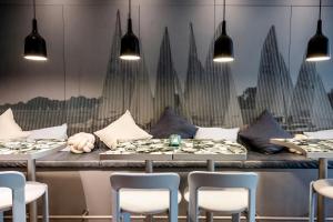 a dining room with two tables and chairs at Motel One Hamburg-Alster in Hamburg +45 photos