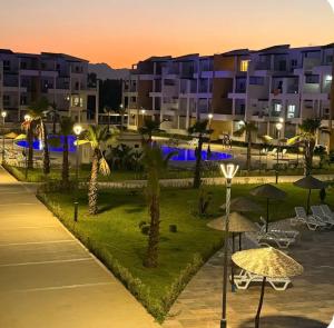 a view of a resort with tables and umbrellas at night at Appartement suite in Cabo Negro
