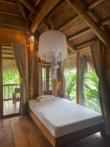 a bedroom with a large bed with a chandelier at Pu Luong Ecostay in Lũng Tiềm
