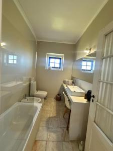 a bathroom with a tub and a toilet and a sink at Casa dos Rebolinhos in Sagres +92 photos