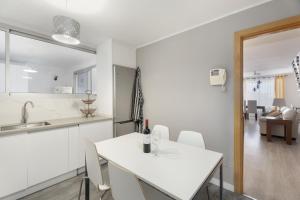 a white kitchen with a white table and chairs at Casa Vistahermosa in Chayofa +26 photos