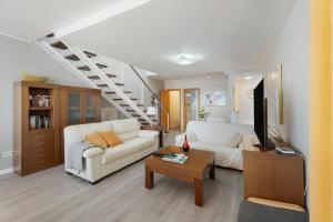 a living room with a white couch and a staircase at Casa Vistahermosa in Chayofa