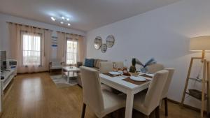 a dining room and living room with a table and chairs at Island Dream Apartment in Olhão