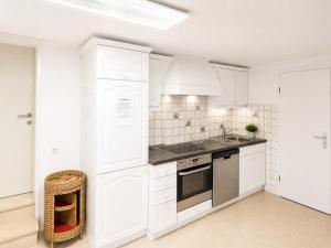 a white kitchen with white cabinets and a sink at Basic Work Stay Rooms - Highspeed WiFi - Easy Self Check-In - Practical and Affordable Stay in Bürs
