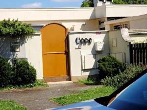 a house with a yellow door on the side of it at Chambre B1 in Toulouse