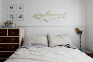 a bedroom with a bed with a shark hanging on the wall at Bruns Surf Shack in Brunswick Heads