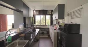 a large kitchen with a sink and a refrigerator at DuriDuri Eco Resort in Bentong
